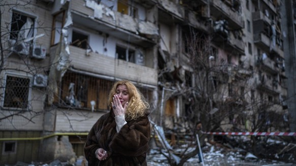 Natali Sevriukova reacts next to her house following a rocket attack the city of Kyiv, Ukraine, Friday, Feb. 25, 2022. (AP Photo/Emilio Morenatti)