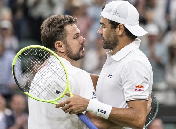epa13076458 Matteo Berrettini (R) of Italy is congratulated at the net by Stan Wawrinka of Switzerland after winning their Men's Singles first round match at the Wimbledon Championships in London ...