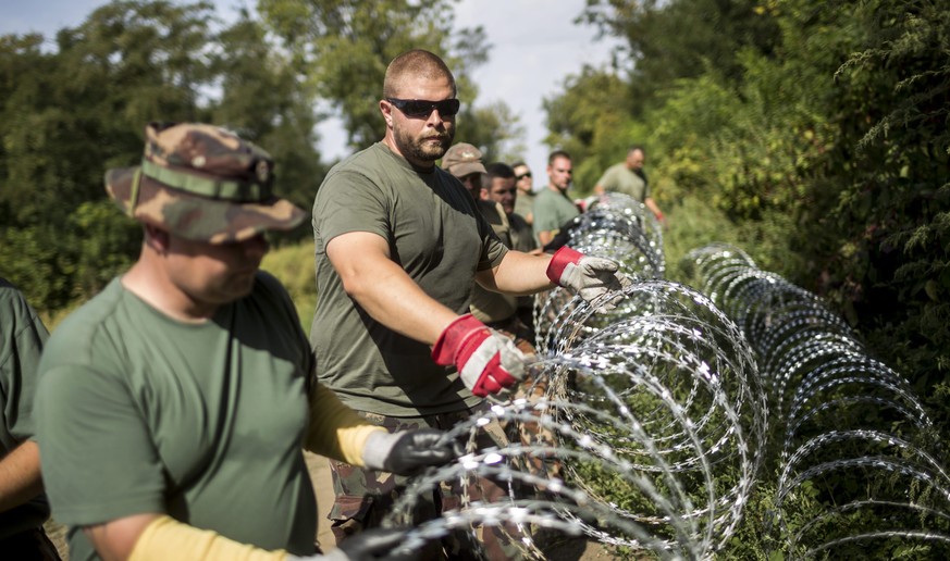Ungarische Soldaten sichern die Grenze zu Kroatien mit Stacheldraht. Sie sollen jetzt durch Reservisten noch verstärkt werden.<br data-editable="remove">