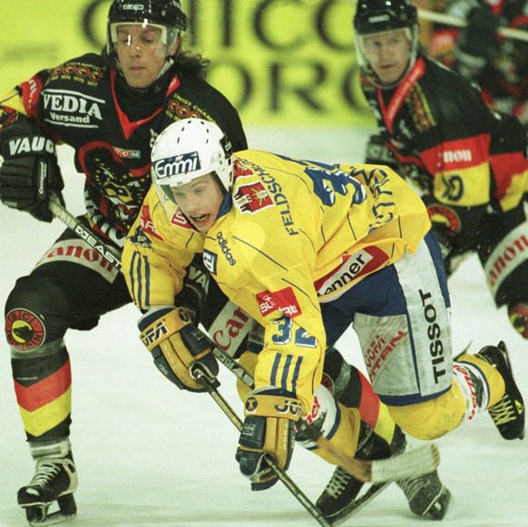 Ivo Ruethemann (Mitte) von Davos in der Zange der Berner Martin Rauch (links) und RŽgis Fuchs (rechts), im Meisterschaftsspiel Davos gegen Bern vom Samstag, 01. November 1997, in Davos. (KEYSTONE/ARNO ...