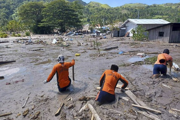 In this photo provided by the Philippine Coast Guard, rescuers continue their search for missing bodies at Barangay Kusiong, Datu Odin Sinsuat, Maguindanao province, southern Philippines on Monday, Oc ...