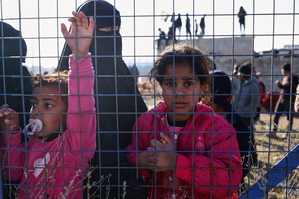 People stand inside the al-Hol camp in northeastern Syria's Hasakeh province, Syria, Wednesday, Jan. 21, 2026, after the withdrawal of the Syrian Democratic Forces (SDF). (AP Photo/Ghaith Alsayed ...
