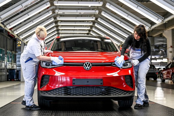 epa09910732 Volkswagen employees clean a Volkswagen ID.5 GTX on an electric cars assembly line at the Volkswagen (VW) vehicle factory in Zwickau, Germany 26 April 2022. In 2021 Volkswagen doubled its  ...