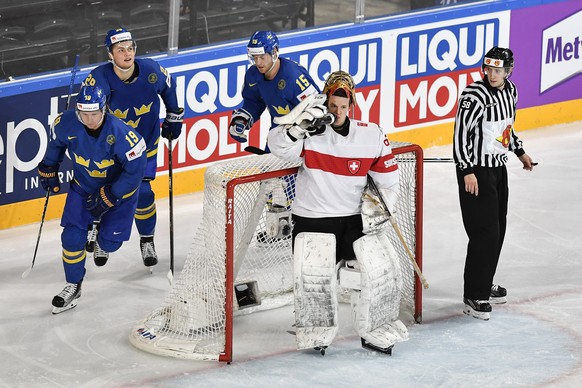 Switzerlandâs goaltender Leonardo Genoni, right, reacts after the first goal against Swedenâs Nicklas Backstrom, William Nylander and Oscar Lindberg, from left, during their Ice Hockey World Champ ...