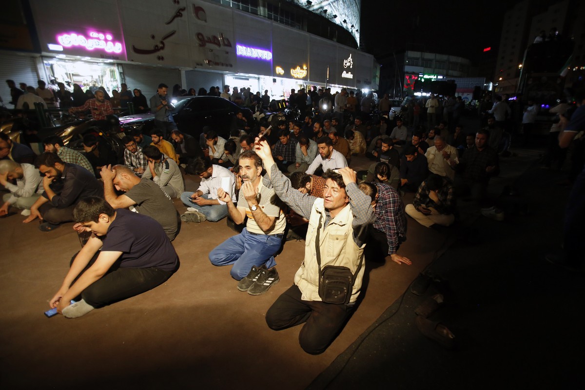 epa11354320 Iranian people pray at the Vali-Asr square for Iranian president following his helicopter accident, Tehran, Iran, 19 May 2024. According to Iranian state media, a helicopter carrying Irani ...