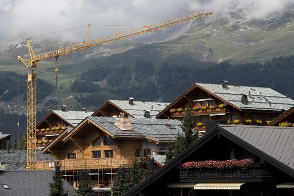 THEMENBILD ZUR KANTONALEN ABSTIMMUNG RAUMPLANUNGSGESETZ WALLIS -- Ein Kran steht neben einem Chalet, aufgenommen am Sonntag, 7. September 2014 im Wallis in Crans-Montana. (KEYSTONE/Ennio Leanza)