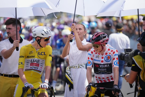 Slovenia's Tadej Pogacar, wearing the overall leader's yellow jersey, and Denmark's Jonas Vingegaard, wearing the best climber's dotted jersey, are shielded from the sun ahead of t ...