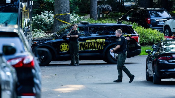 Law enforcement investigate the scene of a fatal house fire on Friday, July 24, 2026, in the in Grand Haven Township, Mich. Ottawa County Sheriff's Office said six children and two adults were fo ...