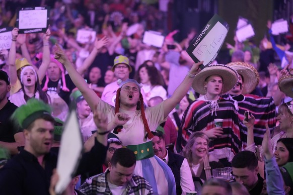 Fans cheer during the final match between Luke Littler of England and Luke Humphries of England at the World Darts Championship, in London, Wednesday, Jan. 3, 2024. (AP Photo/Kin Cheung)