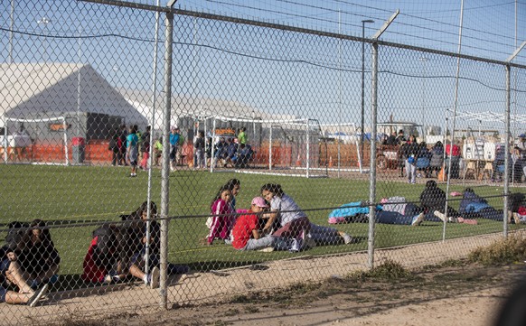 In this Nov. 25, 2018 photo provided by Ivan Pierre Aguirre, migrant teens held inside the Tornillo detention camp look at protestors waving at them outside the fences surrounding the facility in Torn ...