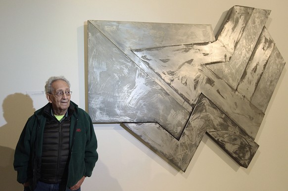 FILE - U.S. artist Frank Stella stands in front of one of his works at an exhibition devoted to him in Warsaw, Poland, Feb. 18, 2016. Stella, a painter, sculptor and printmaker whose constantly evolvi ...