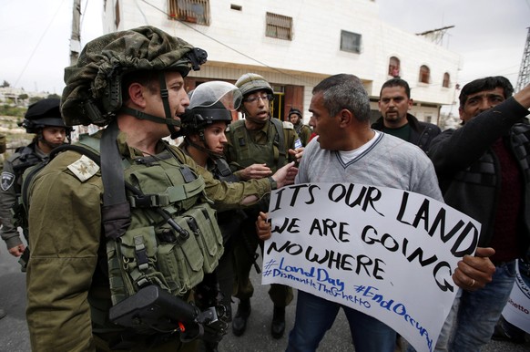 epa05879000 A Palestinian argues with an Israeli army soldier during a protest to mark &#039;National Land Day&#039; near Kiryat Arba settlement in the West Bank city of Hebron, 30 March 2017. On 30 M ...