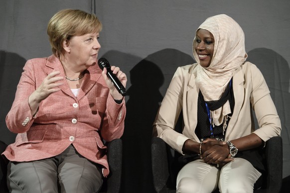 epa06161683 German Chancellor Angela Merkel (L) talks with Nyima Jadama (R), a refugee from Gambia and student at the Non Governmental Organisation (NGO) &#039;Kiron&#039;, during a panel discussion i ...