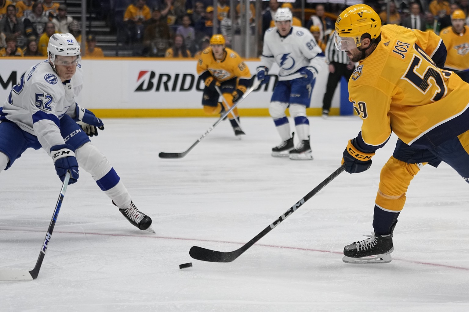 Nashville Predators defenseman Roman Josi, right, shoots the puck past Tampa Bay Lightning forward Maxim Groshev (52) during the second period of a preseason NHL hockey game Wednesday, Sept. 27, 2023, ...