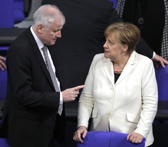 FILE - In this March 14, 2018 file photo German Interior Minister Horst Seehofer, left, talks to German Chancellor Angela Merkel in the German parliament in Berlin. Germany’s new interior minister is  ...