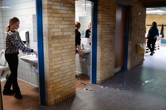 epa08363859 Pupils wash their hands during a break at Korshoej school in Randers, Denmark, 15 April 2020. Nurseries, kindergardens and schools reopen in Denmark after a month-long closure due to sprea ...