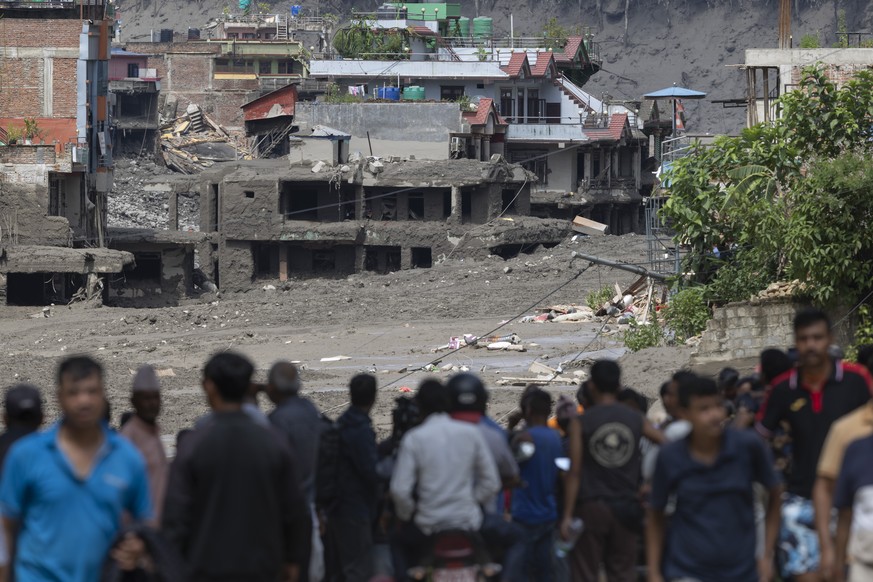 epa13193026 People watch as floodwaters sweep through Trishuli Bazar following a flash flood, in Nuwakot district, Nepal, 26 August 2026. Several people were killed and multiple others were reported m ...