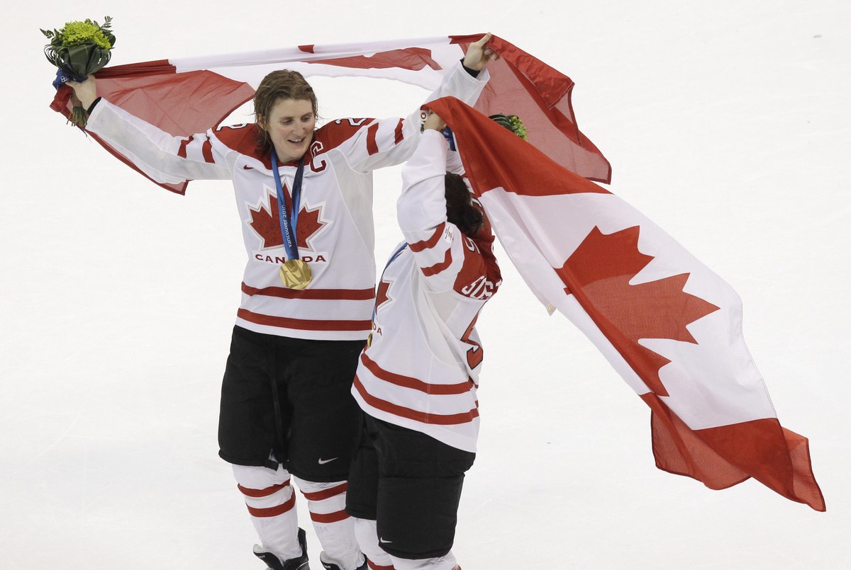Canada's Hayley Wickenheiser, left, and Colleen Sostorics, right, skate around the rink with Canadian flags after Canada beat USA 2-0 to win the women's gold medal ice hockey game at the Van ...