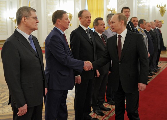 Russian President Vladimir Putin, right, shakes hands with Kremlin Chief of Staff Sergei Ivanov at the award ceremony of the Supreme Military Army at the Kremlin in Moscow, Russia, Friday, ...