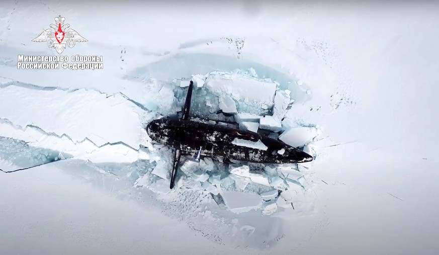 FILE - This photo taken from video released on March 26, 2021 by the Russian Defense Ministry press service shows a Russian nuclear submarine breaking through the Arctic ice during military drills at  ...