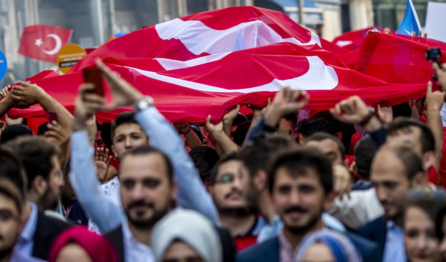 epa06825439 Supporters of Turkish President Recep Tayyip Erdogan carry a large Turkish flag during an election campaign rally of Justice and Development Party (AK Party) in Istanbul, Turkey, 20 June 2 ...