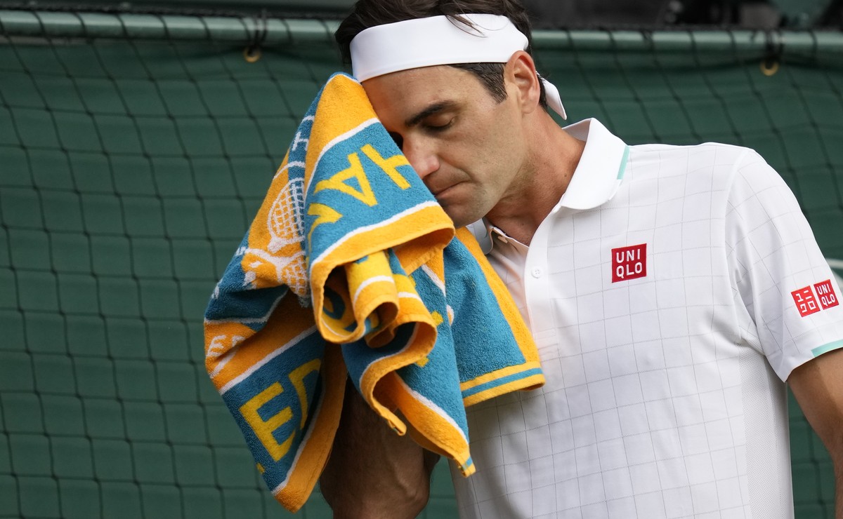 Switzerland's Roger Federer wipes his face with a towel during the men's singles quarterfinals match against Poland's Hubert Hurkacz on day nine of the Wimbledon Tennis Championships in ...