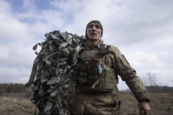 A Ukrainian paratrooper of 95 Air Assault brigade carries a masking net after firing a MSLR BM-21 &quot;Grad&quot; rocket launcher towards Russian positions at the frontline near Kreminna, Ukraine, Th ...