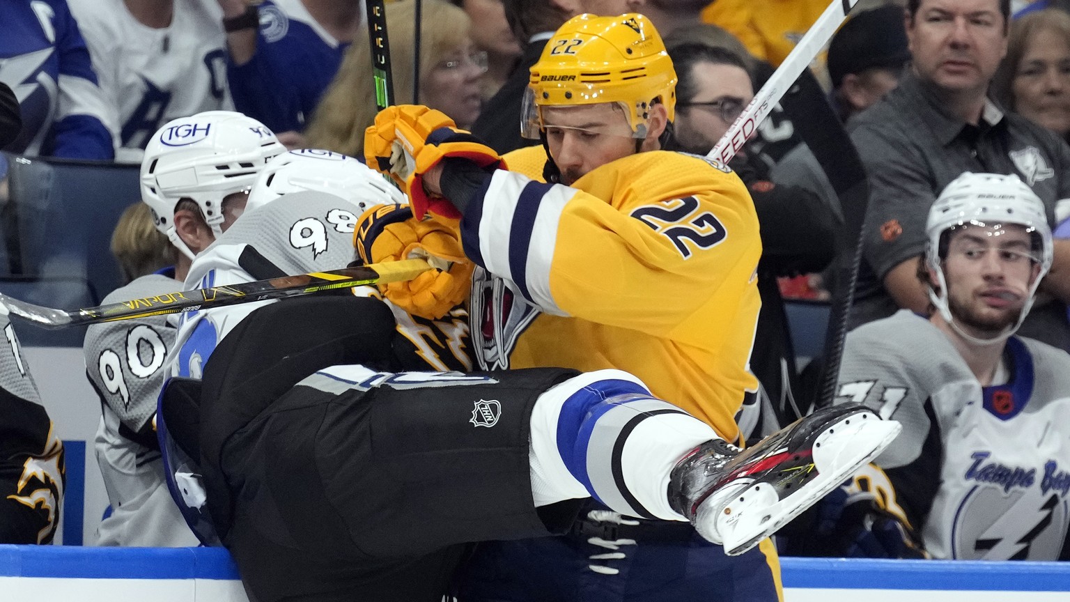 Nashville Predators right wing Nino Niederreiter (22) checks Tampa Bay Lightning defenseman Mikhail Sergachev (98) into the dasher during the first period of an NHL hockey game Thursday, Dec. 8, 2022, ...