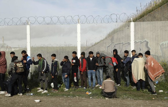 FILE - In this Oct. 27, 2016 file photo, Migrants queue for busses to leave the makeshift migrant camp known as &quot;the jungle&quot; near Calais, northern France. Refugees who stayed at such camps d ...