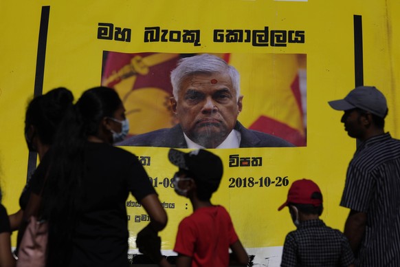 People watch propaganda materials displayed against prime minister Ranil Wickremesinghe outside president Gotabaya Rajapaksa&#039;s office three days after it was stormed by anti government protesters ...