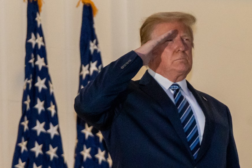 epa08723080 US President Donald J. Trump salutes after returning to the White House, in Washington, DC, USA, 05 October 2020, following several days at Walter Reed National Military Medical Center for ...
