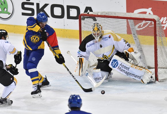 Davos&#039;s Dino Wieser, left, tries to shoot a goal back hand against Rouen&#039;s goalkeeper Dany Sabourin (CA), right, during the Champions Hockey League Group G hockey match between Switzerland&# ...