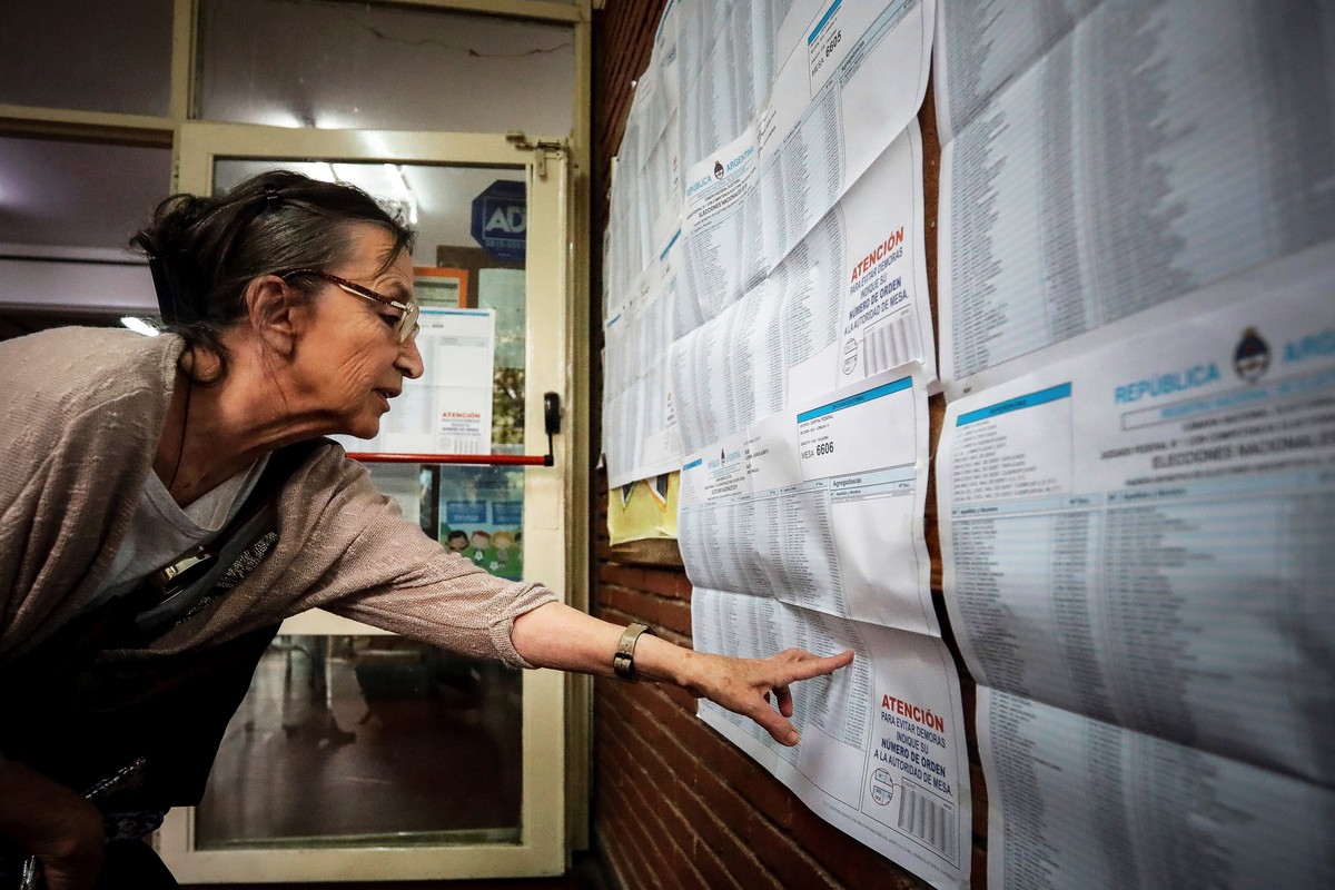 epa07953360 A voter checks the election roll upon her arrival at a polling station in Buenos Aires, Argentina, 27 October 2019. About 33.8 millions Argentinian voters are called to elect their new Pre ...