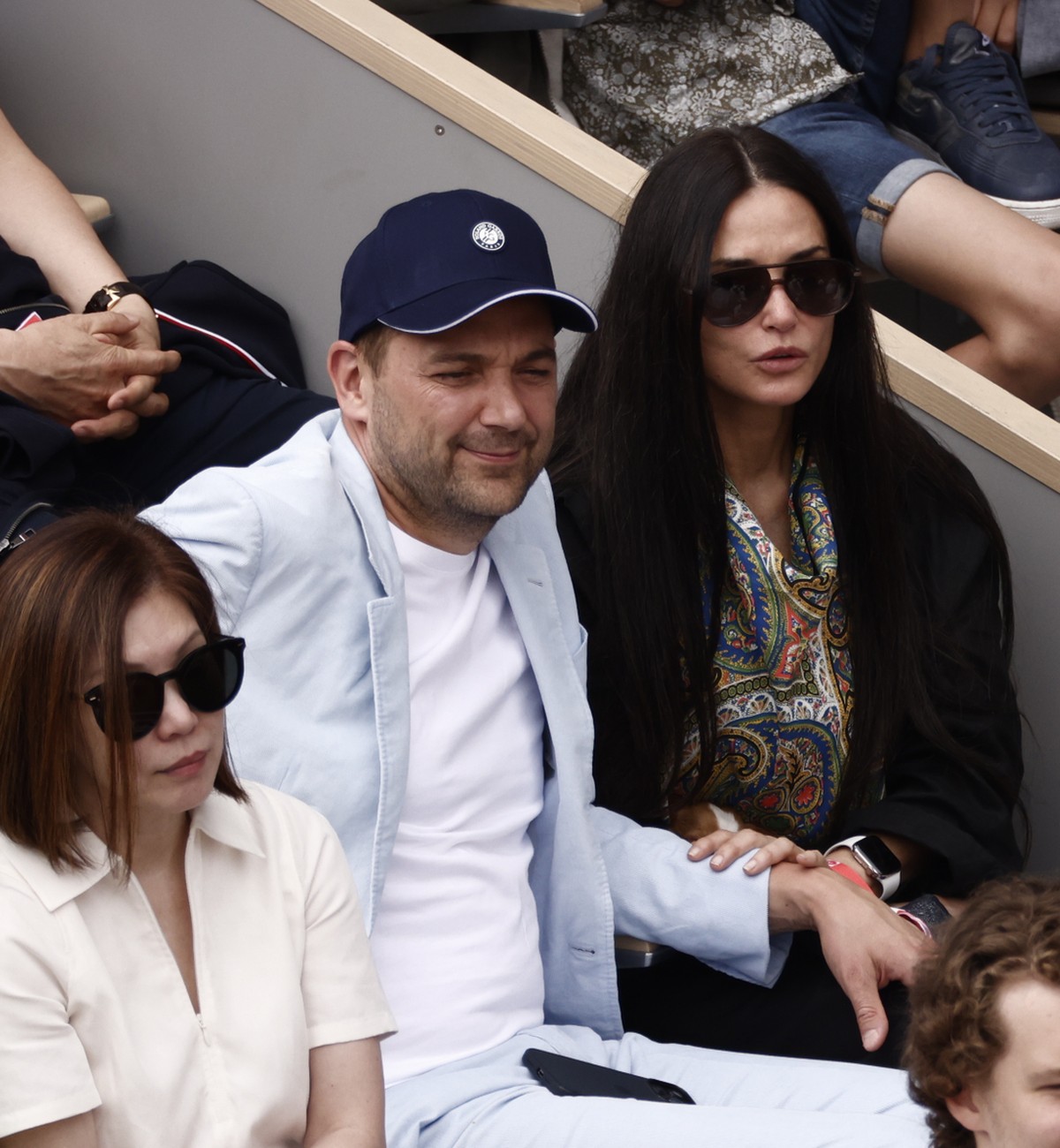 epa09997483 US actor Demi Moore (C) and Swiss chef Daniel Humm (C-R) watch as Rafael Nadal of Spain plays Casper Ruud of Norway in their Men?s Singles final match during the French Open tennis tournam ...
