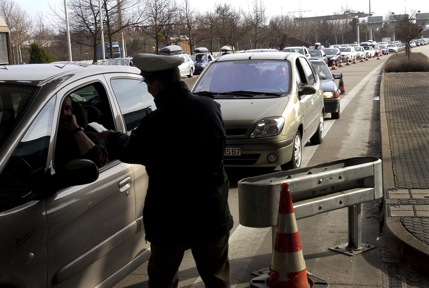 Ein deutscher Grenzbeamter kontrolliert am Sonntag 7. Maerz 2004 am Basler Autobahnzoll Weil/Basel die einreisenden Autofahrer. Durch verschaerfte Kontrollen der deutschen Beamten kommt es seit Samsta ...