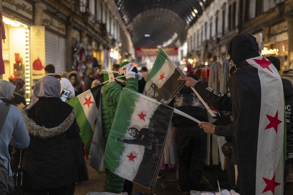 A vendor sells new Syrian flags in Al-Hamidiyeh Souq on New Years Eve, in Damascus, Syria, Tuesday, Dec. 31, 2024. (AP Photo/Mosa&#039;ab Elshamy)