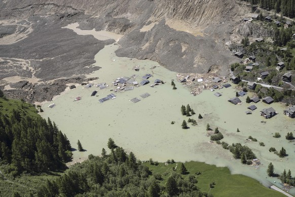 Water from the Lonza river flows over the mud and stone, after the formation of a lake on the last houses of the village of Blatten, Switzerland, Friday, May 30, 2025. (Jean-Christophe Bott/Keystone v ...