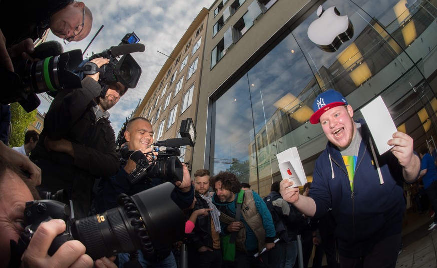epa04406916 20-year old Marcel Gaisbachgrabner from Gmunden in Austria, cheers as he steps out of an Apple store holding two new iPhone 6 in his hands surrounded by photographers in the city centre of ...