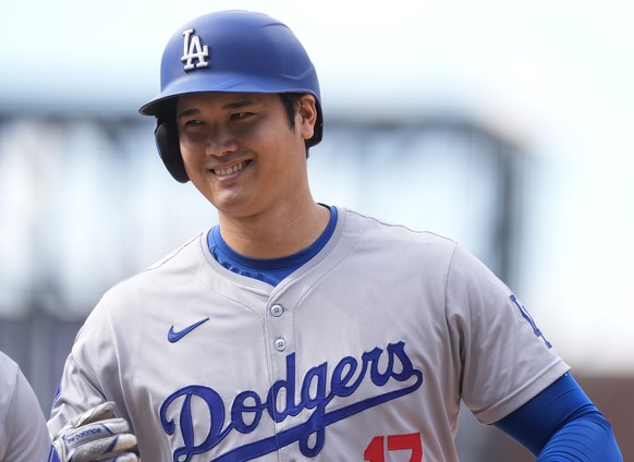 FILE - Los Angeles Dodgers&#039; Shohei Ohtani smiles after reaching first base on a single off Colorado Rockies relief pitcher Seth Halvorsen in the eighth inning of a baseball game Sept. 29, 2024, i ...