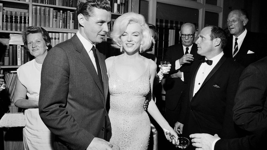 Marilyn Monroe im teuer versteigerten Kleid. Neben ihr steht John F. Kennedys Schwager, Steve Smith.&nbsp;