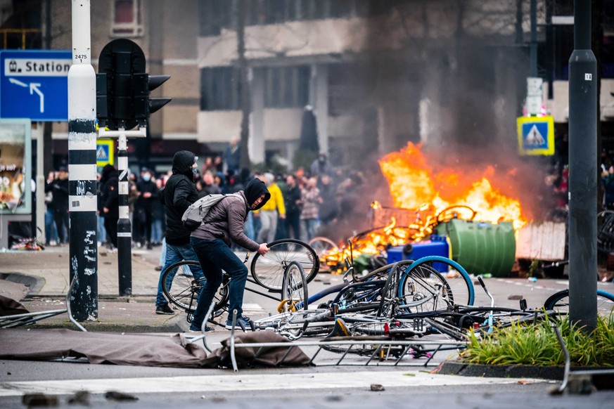 epa08964077 People protest against coronavirus restrictions in 18 Septemberplein in Eindhoven, the Netherlands, 24 January 2021 (issued 25 January 2021). Clashes between police and protesters erupted  ...