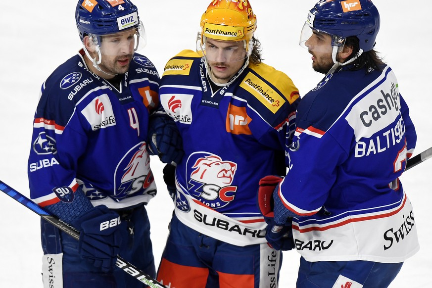 Der Zuercher Sven Andrighetto, Mitte, mit Patrick Geering links und Phil Baltisberger, rechts, nach dem zweiten Tor fuer die Lions beim Eishockeyspiel der National League ZSC Lions gegen den EV Zug im ...