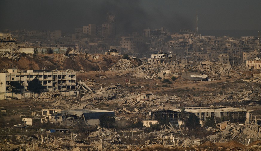 Buildings that were destroyed during the Israeli ground and air operations stand in the northern Gaza Strip during the sunrise, as seen from southern Israel, Friday, Oct. 17, 2025. (AP Photo/Leo Corre ...