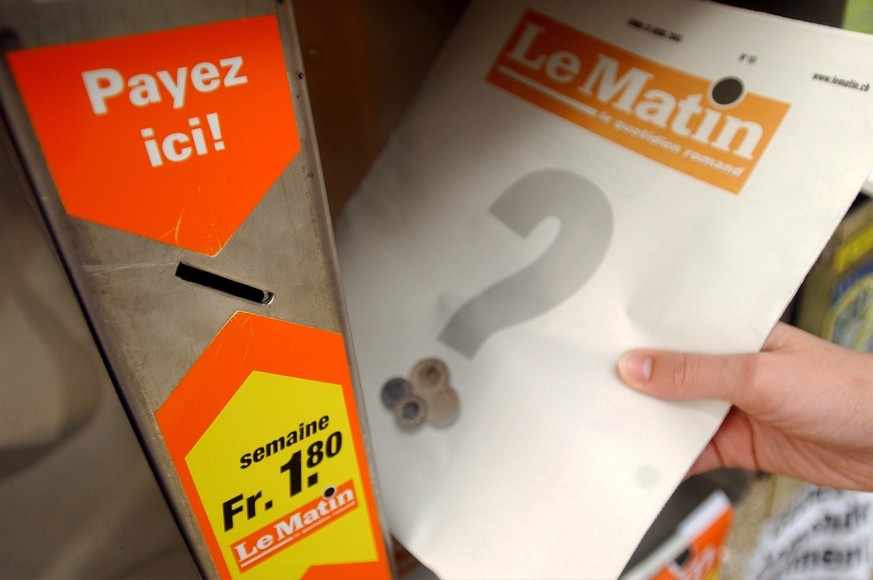 Une lectrice sort d&#039;une cassette un exemplaire du journal, Le Matin, ce lundi 21 avril 2003 a Rolle, Vaud. Le quotidien romand, Le Matin, lance une campagne de sensibilisation contre les vols cro ...