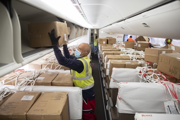 Workers unload boxes containing facial masks and medical syringe pump from China from an aircraft Boeing 777 of Swiss International Air Lines at the Zurich Aeroport, in Zurich, Switzerland, Monday, Ap ...