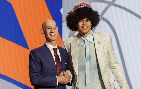 epa11440858 Swiss basketball player Kyshawn George (R) shakes hands with Commissioner of the NBA Adam Silver (L) after getting drafted by the New York Knicks, later drafted by the Washington Wizards,  ...