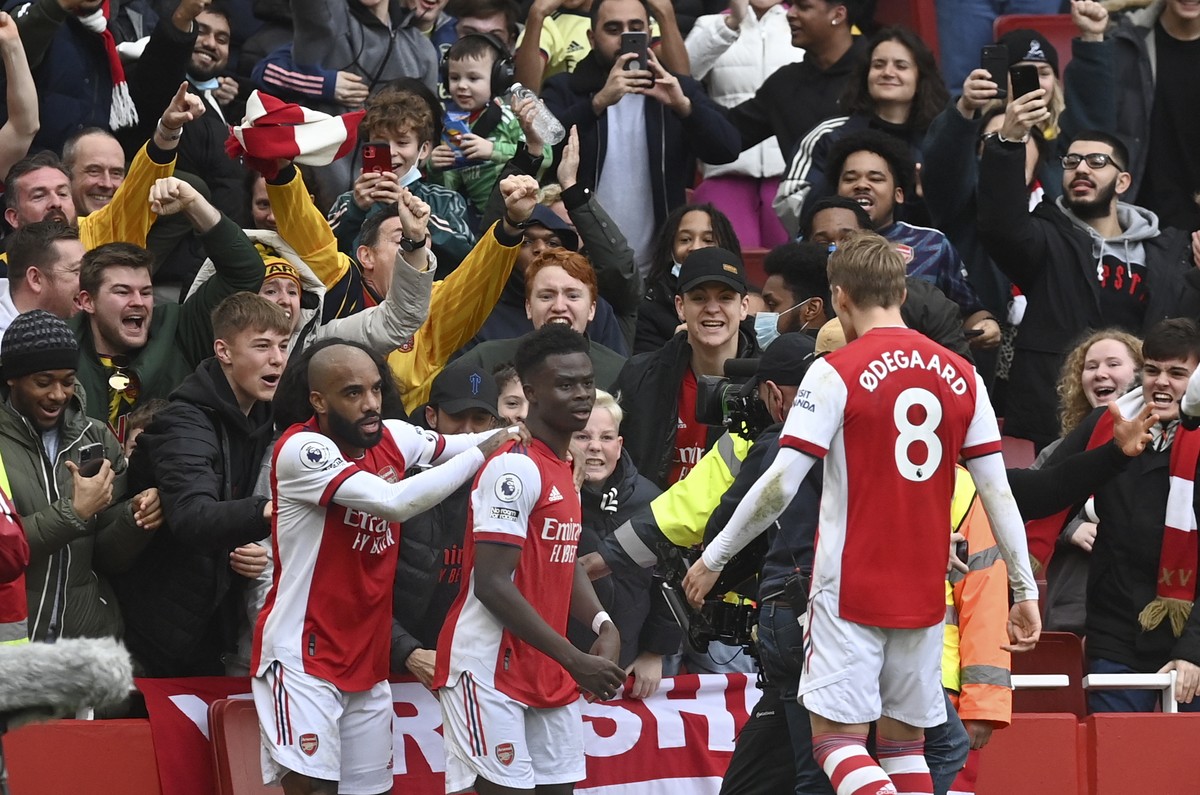 epa09662694 Bukayo Saka (C) of Arsenal celebrates with teammate Alexandre Lacazette (L) after scoring the 1-0 lead during the English Premier League match between Arsenal London and Manchester City in ...