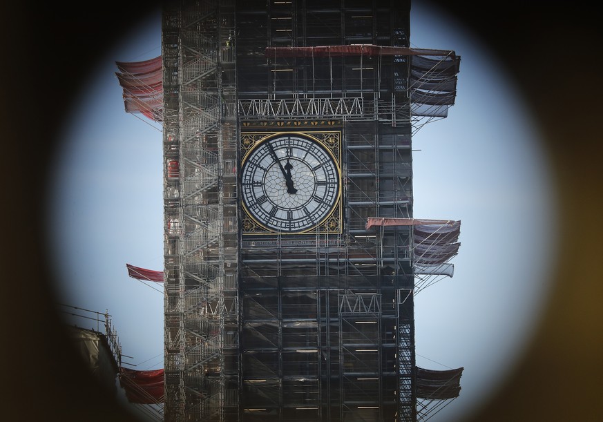 Shrouded in scaffolding during renovation work, Big Ben&#039;s clock tower shows five minutes to twelve, photographed through a binocular stand in London, Tuesday, Jan. 22, 2019. British Prime Ministe ...