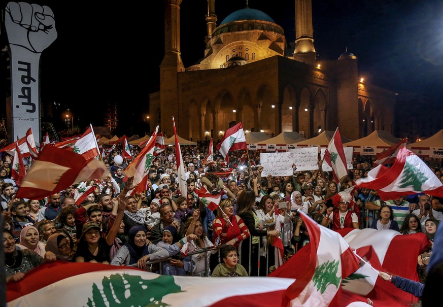 epa08022977 Lebanese protesters shout slogans and carry the national flags during an anti-government protest at Martyrs&#039; square in Beirut, Lebanon, 24 November 2019. Protests in Lebanon are conti ...