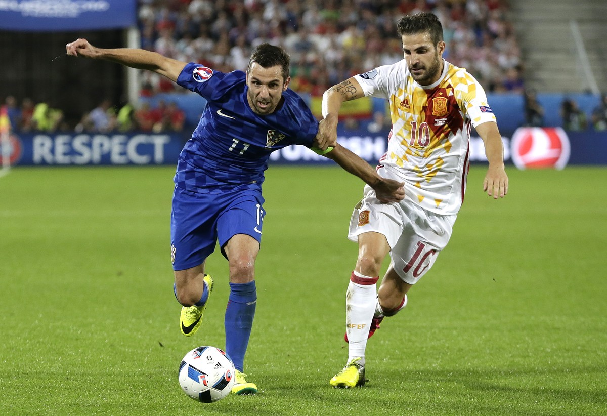 Croatia's Dario Srna, left, is challenged by Spain's Cesc Fabregas during the Euro 2016 Group D soccer match between Croatia and Spain at the Nouveau Stade in Bordeaux, France, Tuesday, June ...